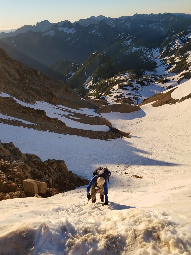 Jenny climbing the steep, frozen snow to the col south of Black Peak.